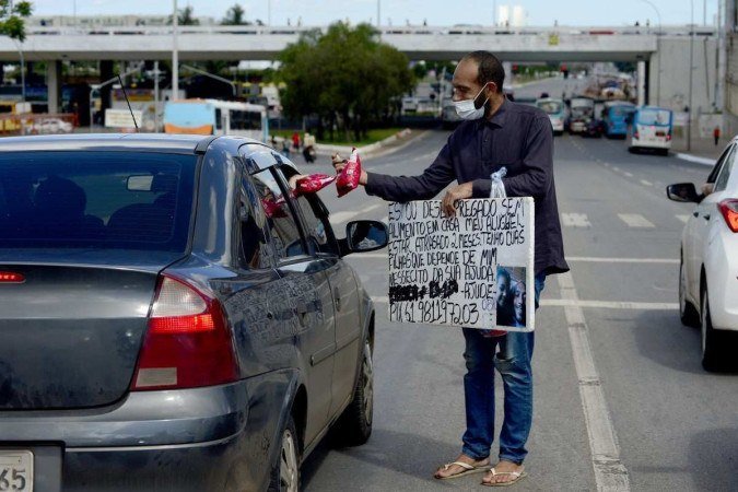 Pedro Henrique Ramos oferece pipoca e pede ajuda em um sinal próximo à Rodoviária do Plano