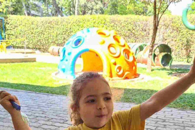 Aluna da Escola Canarinho comendo mamão no lanche da escola