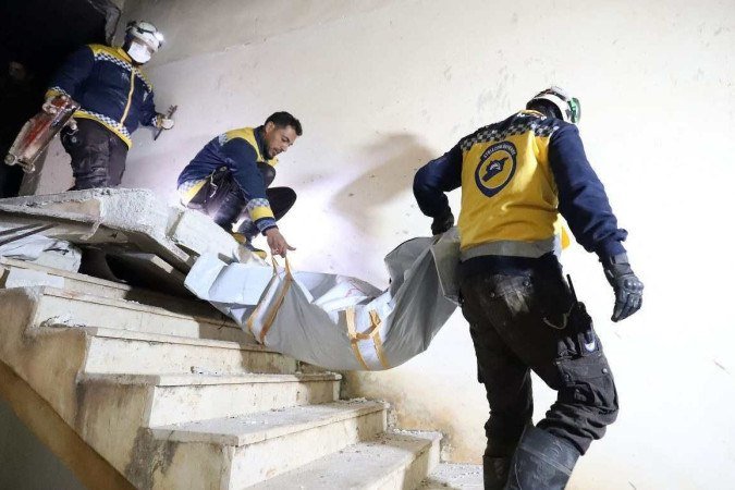  Members of Syrian civil defence known as the White Helmets, evacaute a body on February 3, 2022 following an overnight raid by US special operations forces against suspected jihadists in northwestern Syria which left at least nine people dead, including three civilians. (Photo by Abdulaziz KETAZ / AFP)
      