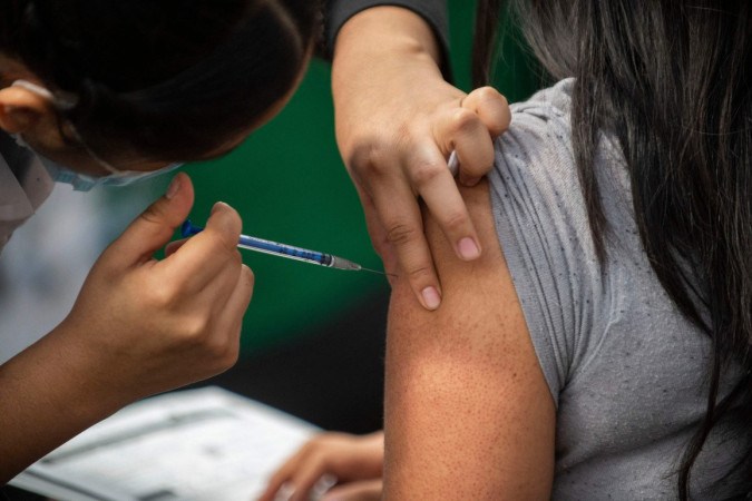 Vacinação e evitar aglomerações é a melhor forma de se proteger contra a covid-19, segundo especialistas -  (crédito: Claudio Cruz/AFP)