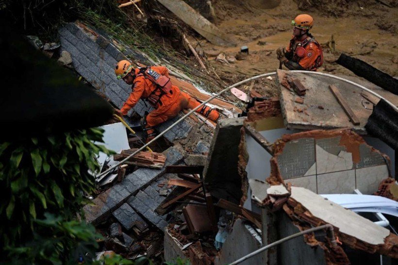 Membros da equipe de resgate dos bombeiros levantam escombros para procurar sobreviventes após um deslizamento de terra em Petrópolis, Brasil, em 16 de fevereiro de 2022.