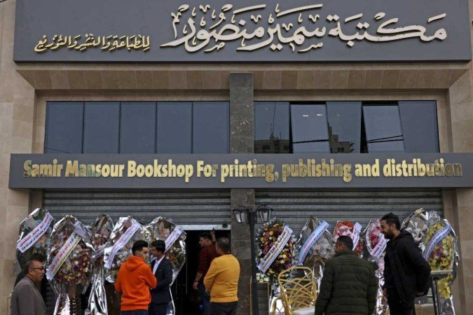  Workers prepare for the opening of the new Samir Mansour bookshop that was destroyed during last year's 11-day war between Israel and the Palestinian Hamas movement, in Gaza city on February 17, 2022. - Mansour?s beloved bookshop has been rebuilt and restocked following an international fundraiser. (Photo by MOHAMMED ABED / AFP)
      