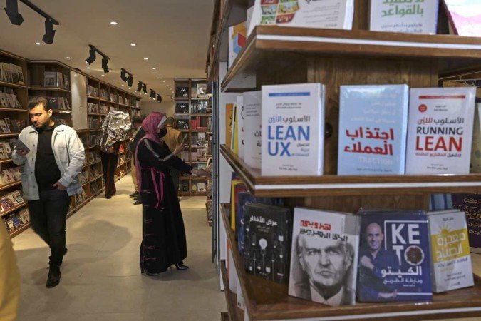  Palestinians attend the reopening of the new Samir Mansour bookshop after it was destroyed during last year's 11-day war between Israel and the Palestinian Hamas movement, in Gaza city on February 17, 2022. - Mansour?s beloved bookshop has been rebuilt and restocked following an international fundraiser. (Photo by MOHAMMED ABED / AFP)
      