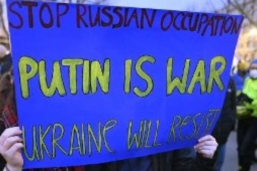 Manifestantes pró-Ucrânia seguram um cartaz durante uma manifestação em frente à embaixada russa em Berlim em 22 de fevereiro de 2022, após o reconhecimento da Rússia aos separatistas do leste ucraniano. A Rússia enfrentou uma furiosa reação diplomática e econômica global depois que o presidente Vladimir Putin ordenou que suas forças entrassem na Ucrânia para proteger duas regiões separatistas.