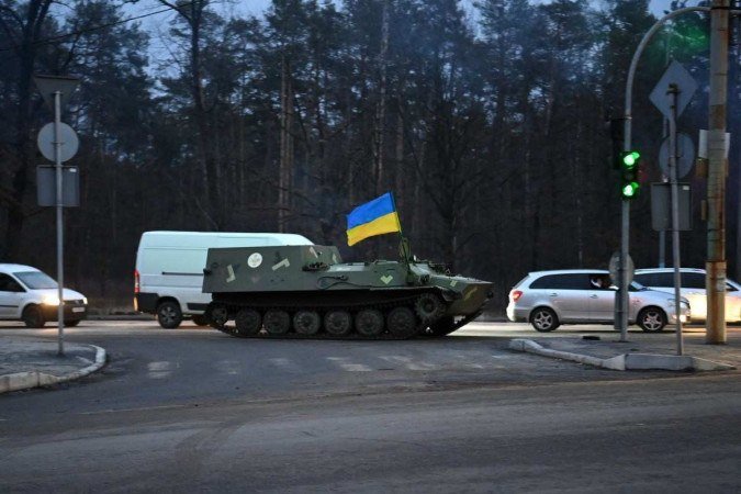 This photograph taken on February 24, 2022 shows a MT-LB-S armored medical evacuation vehicle, bearing the Ukrainian flag, on the road in northwest Kyiv. - Russian and Ukrainian forces are battling for control of an airbase on the northern outskirts of Kyiv, a senior Ukrainian officer said on February 24, 2022, as dozens of attack helicopters swooped on the area. (Photo by Daniel LEAL / AFP) - (crédito: Daniel LEAL / AFP) This photograph taken on February 24, 2022 shows a MT-LB-S armored medical evacuation vehicle, bearing the Ukrainian flag, on the road in northwest Kyiv. - Russian and Ukrainian forces are battling for control of an airbase on the northern outskirts of Kyiv, a senior Ukrainian officer said on February 24, 2022, as dozens of attack helicopters swooped on the area. (Photo by Daniel LEAL / AFP) - (crédito: Daniel LEAL / AFP)