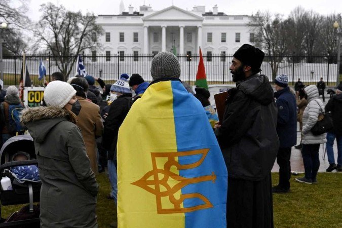 Manifestantes protestam em apoio à Ucrânia em frente à Casa Branca, em Washington, DC, em 24 de fevereiro de 2022. - O presidente russo, Vladimir Putin, lançou uma invasão em larga escala da Ucrânia em 24 de fevereiro, desencadeando ataques aéreos e ordenando tropas terrestres em todo o país. fronteira nos combates que, segundo as autoridades ucranianas, deixaram dezenas de mortos.       -  (crédito: OLIVIER DOULIERY / AFP)
