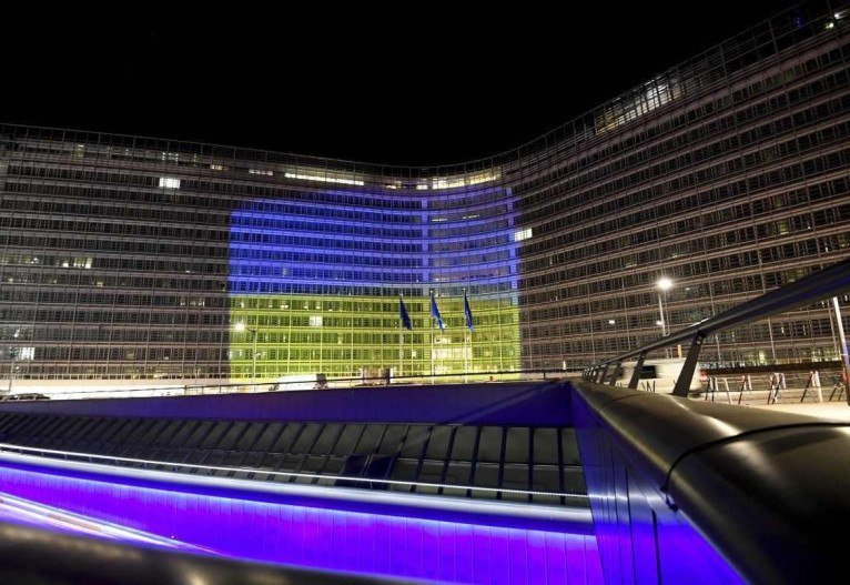 Esta visão geral mostra o prédio da Comissão Europeia iluminado com as cores da bandeira ucraniana durante a cúpula de emergência sobre a crise Rússia-Ucrânia na sede da UE em Bruxelas em 24 de fevereiro de 2022.       Caption 