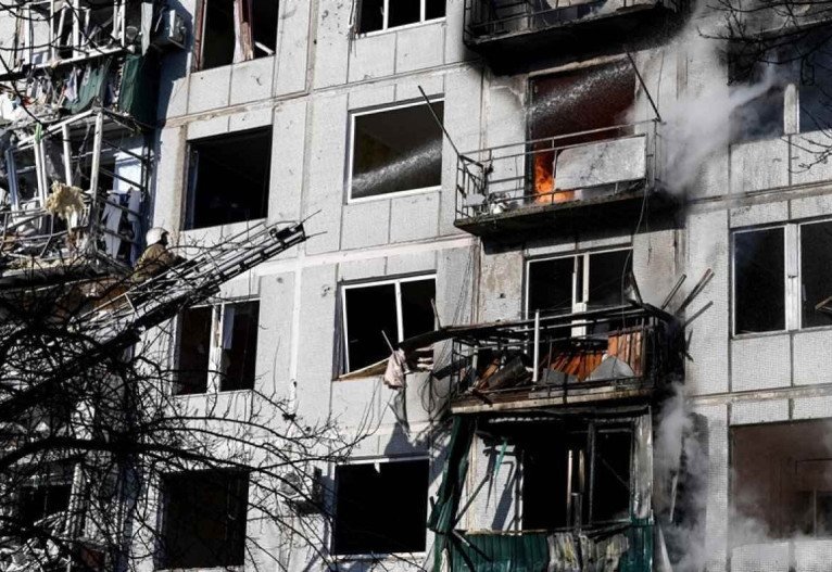  Firefighters work on a fire on a building after bombings on the eastern Ukraine town of Chuguiv on February 24, 2022, as Russian armed forces are trying to invade Ukraine from several directions, using rocket systems and helicopters to attack Ukrainian position in the south, the border guard service said. - Russia's ground forces on Thursday crossed into Ukraine from several directions, Ukraine's border guard service said, hours after President Vladimir Putin announced the launch of a major offensive. Russian tanks and other heavy equipment crossed the frontier in several northern regions, as well as from the Kremlin-annexed peninsula of Crimea in the south, the agency said. (Photo by ARIS MESSINIS / AFP)
      