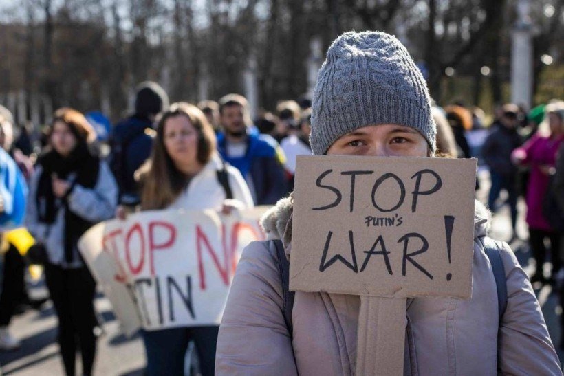 Ukrainian and Polish demonstrators take part in a protest against Russia's invasion of Ukraine, in front of the Russian embassy in Warsaw, Poland, on February 24, 2022.   (Photo by Wojtek RADWANSKI / AFP)

      Caption 