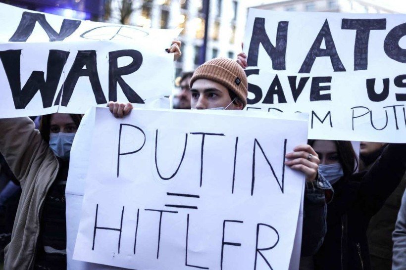  A protester holds a placard during a rally against Russia's military operation in Ukraine, in front of the russian mission in Brussels on February 24, 2022. Russian President Vladimir Putin launched a full-scale invasion of Ukraine on February 24, killing dozens and forcing hundreds to flee for their lives in the pro-Western neighbour. Russian air strikes hit military facilities across the country and ground forces moved in from the north, south and east, triggering condemnation from Western leaders and warnings of massive sanctions. (Photo by Kenzo TRIBOUILLARD / AFP)

      
