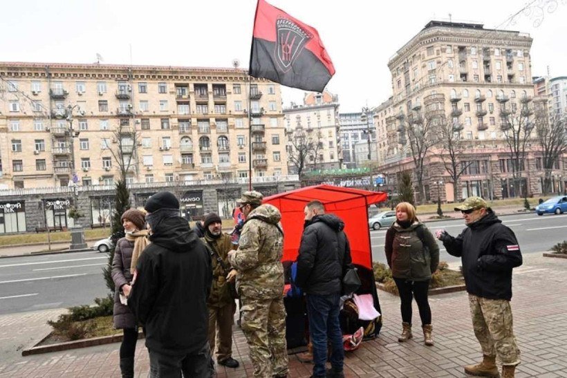  People queue to volunteer in a battalion initiates by far-right movement 'Right Sector' in Kyiv city centre on February 24, 2022 as Russia's ground forces invaded Ukraine from several directions today, encircling the country within hours of Russian President announcing his decision to launch an assault. - Heavy Russian tanks and other equipment crossed the frontier in a string of northern regions as well as from the Kremlin-annexed peninsula of Crimea in the south. They were also advancing into the Western-backed government's territory along the eastern front, where a separatist insurgency has claimed more than 14,000 lives since 2014. (Photo by Sergei SUPINSKY / AFP)
      