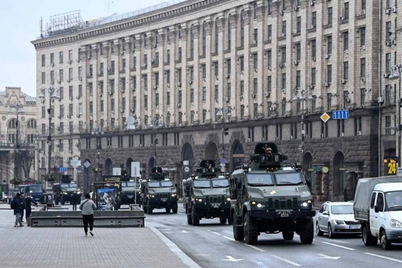  Ukrainian military vehicles move past Independence square in central Kyiv on February 24, 2022. - Air raid sirens rang out in downtown Kyiv today as cities across Ukraine were hit with what Ukrainian officials said were Russian missile strikes and artillery. Russian President announced a military operation in Ukraine on February 24, 2022, with explosions heard soon after across the country and its foreign minister warning a "full-scale invasion" was underway. (Photo by Daniel LEAL / AFP)
      