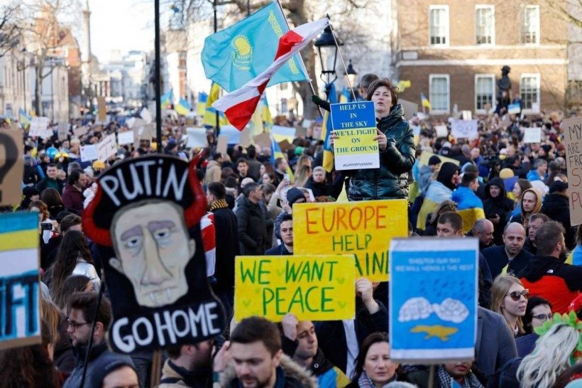  Demonstrators hold placards at a protest rally in central London on February 26, 2022 following Russias
      