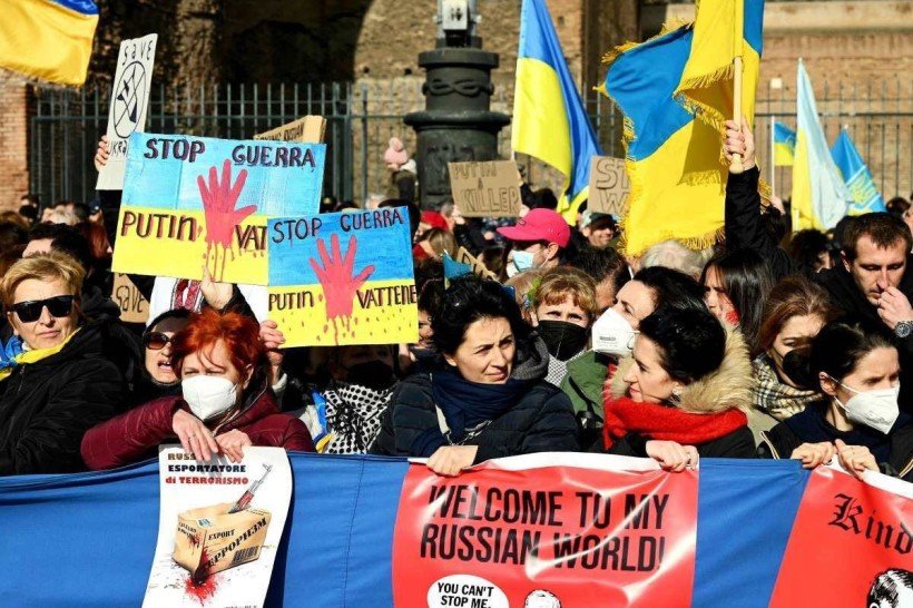  Protesters hold placards as they attend a demonstration in support of Ukraine, in Rome on February 27, 2022. Italy said that, it would close its airspace to Russia flights, joining other European countries in ramping up sanctions against Moscow over its invasion of Ukraine (Photo by Vincenzo PINTO / AFP)
      