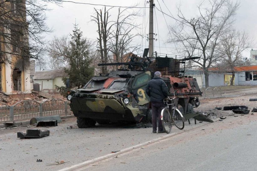  A man looks at an Ukrainian armored personnel carrier (APC) BTR-4 destroyed as a result of fight not far from the center of Ukrainian city of Kharkiv, located some 50 km from Ukrainian-Russian border, on February 28, 2022. (Photo by Sergey BOBOK / AFP)
      