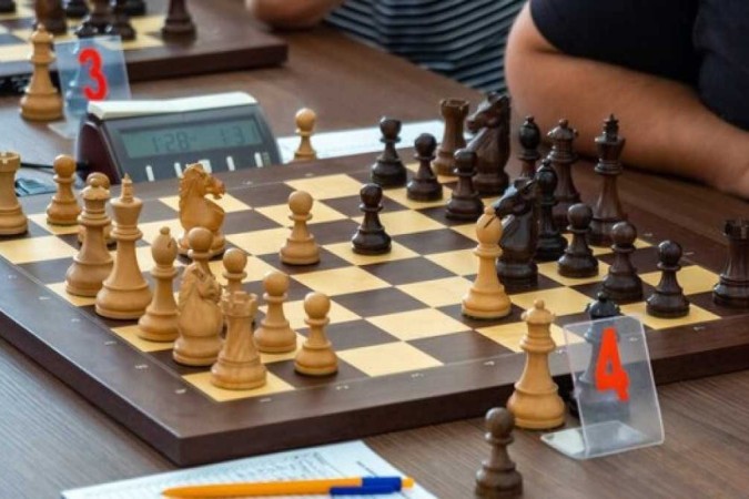 Duas pessoas jogando xadrez, uma das quais é um jogo de xadrez.