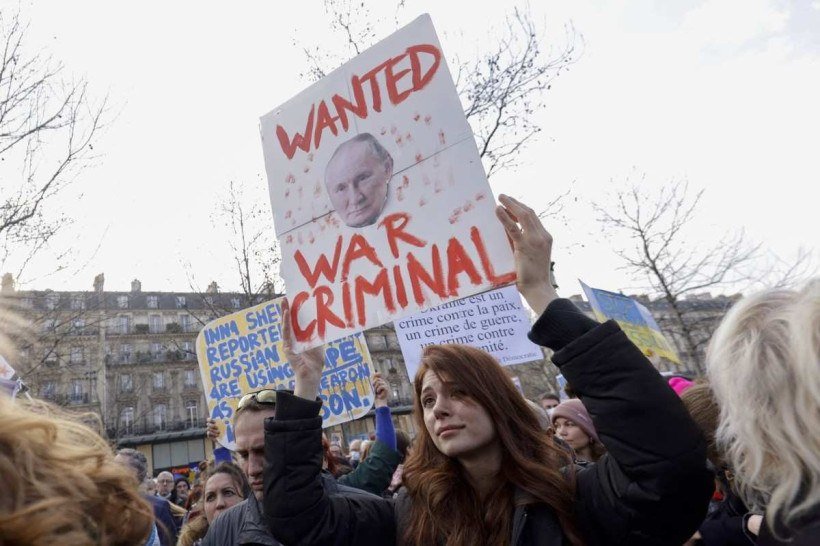  A demonstrator holds a banner with the face of Vladimir Putin  during a protest against Russia's military invasion of Ukraine at Place de la Republique in Paris on March 5, 2022. (Photo by Sameer Al-DOUMY / AFP)
      