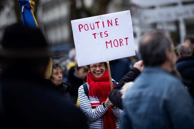  A placard that reads, 'Putin you are dead', is held up during a rally in support of Ukraine, ten days after Russia invaded its neighbour, in Nantes, western France on March 5, 2022. (Photo by Loic VENANCE / AFP)
      