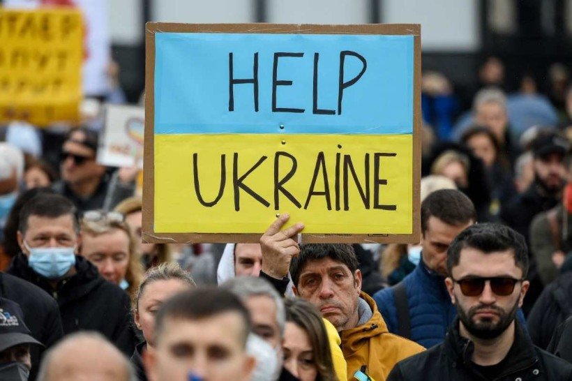  A protestor holds a sign readong 'Help Ukraine' during a demonstration in support of Ukraine and to protest against Russia's invasion of the country, on the Plaza Catalunya square in Barcelona, on March 6, 2022. - The number of people fleeing Russia's invasion of Ukraine has topped 1.5 million, making it Europe's fastest growing refugee crisis since World War II, the United Nations said on March 6. UN officials said they expected the wave of refugees to intensify further as the Russian army pressed its offensive, particularly toward the Ukranian capital Kyiv. 
      