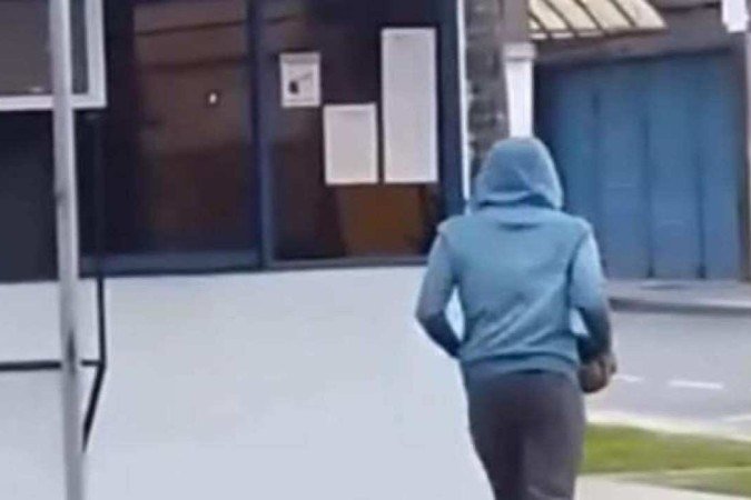 Vídeo que circula nas redes sociais mostra o momento no qual o autor se aproxima do posto policial carregando um tijolo - (crédito: Redes sociais) Vídeo que circula nas redes sociais mostra o momento no qual o autor se aproxima do posto policial carregando um tijolo - (crédito: Redes sociais)