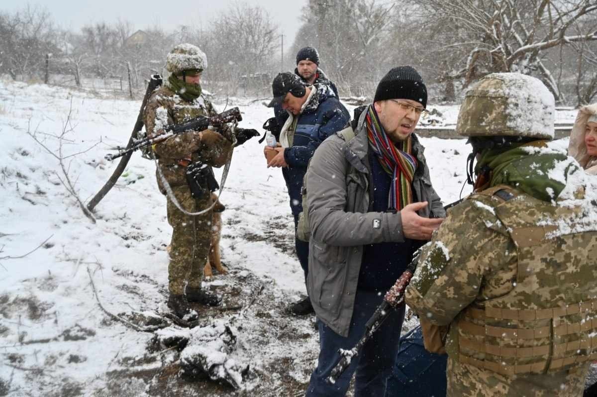  Ukrainian soldiers check documents of men leaving the city of Irpin, on March 8, 2022. - More than two million people have fled Ukraine since Russia launched its full-scale invasion less than two weeks ago, the United Nations said on March 8, 2022. (Photo by Sergei SUPINSKY / AFP)
      