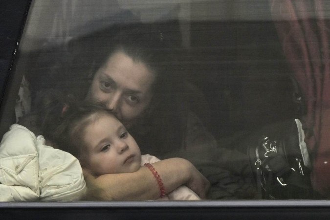 A Ukrainian woman hugs her daughter while crossing the Polish border in a bus