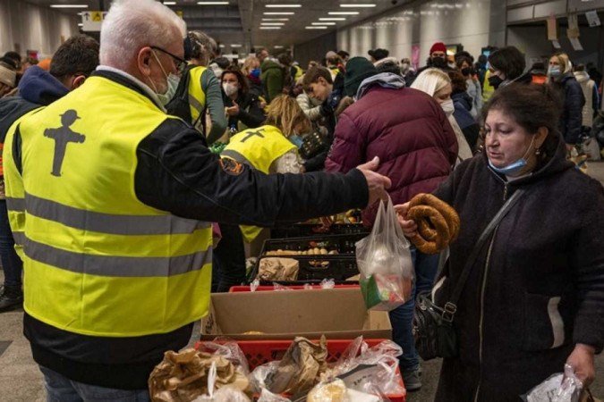 Voluntários distribuem alimentos na estação central de trem, em Berlim, para refugiados da Ucrânia -  (crédito: John MACDOUGALL / AFP)