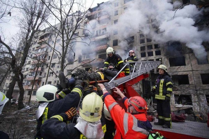 Bombeiros retiram morador de prédio atingido em bombardeio em Obolon, distrito de Kiev: combates se aproximam da capital  -  (crédito: Serviços de Emergência do Estado da Ucrânia/AFP)