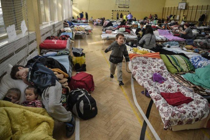 Garoto brinca em abrigo na fronteira com a Polônia    