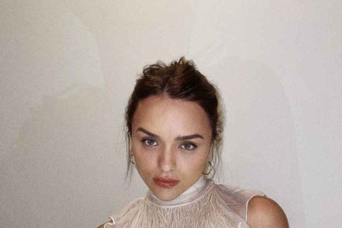 Rafa Kalimann posou com blusa que cobriu o pescoço delicadamente e deixou os braços de fora. O foco vai todo para a região do busto e abdômen, preenchido por plumas. O cabelo preso ajuda ainda mais nessa ideia