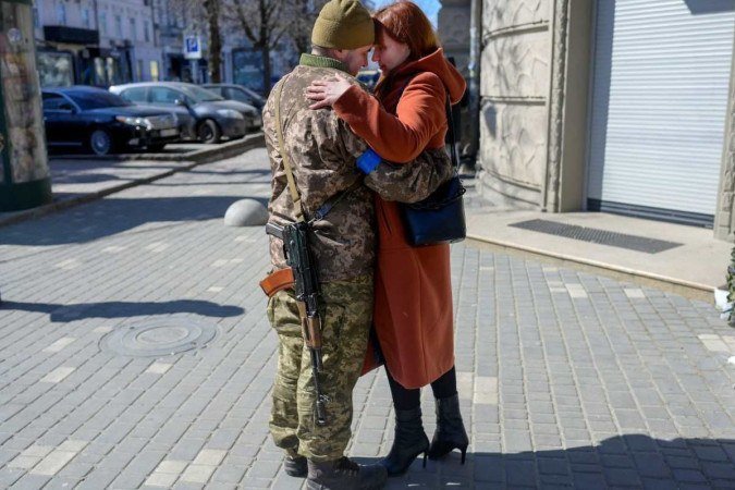  Igor, a 40 year-old Ukranian soldier embraces his wife in front of his military basement in the center of Odessa on March 17, 2022. Odessa, which Ukraine fears could be the next target of Russias
      Caption 