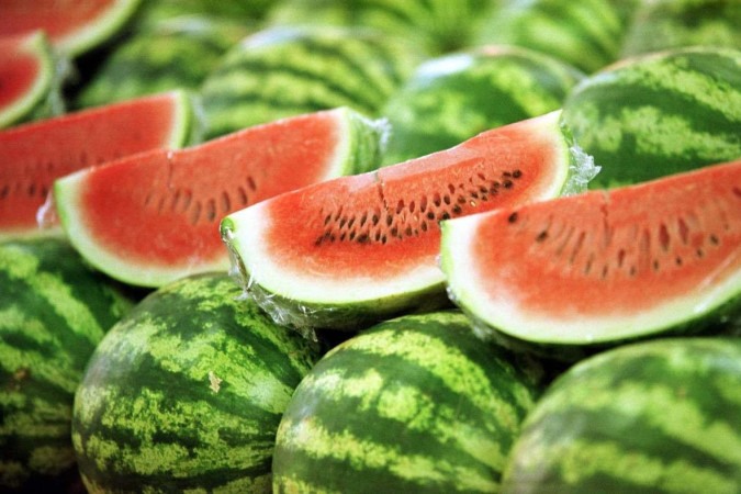 O adolescente utilizou uma colher para dividir a fruta com O adolescente utilizou uma colher para dividir a fruta com