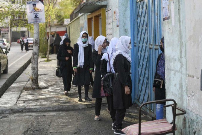 Adolescentes chegam à escola, em Cabul, momentos antes do talibã voltar atrás e determinar o fechamento das instituições de ensino -  (crédito: Ahmad SAHEL ARMAN / AFP)