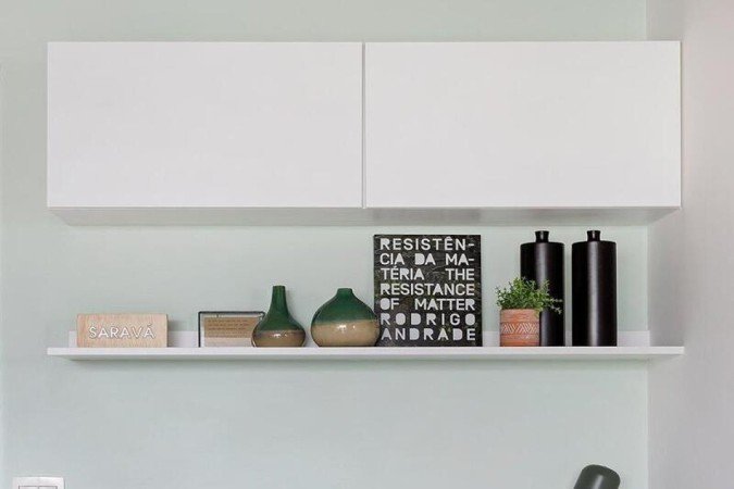 Projeto do escritório Oliva Arquitetura no apartamento de 35m², com adega inserida na lateral da bancada de home office para aproveitar o espaço limitado
