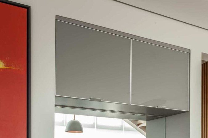 A marcenaria delineou o espaço do bar: na parte de cima, bandeja com copos e bebidas destiladas; encaixada no vão, a adega climatizada
