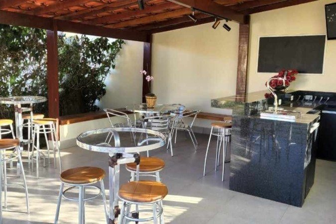 Bar em casa feito com bancada de mármore e espaço amplo