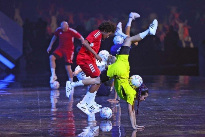  Os atletas se apresentam com bolas durante o sorteio da Copa do Mundo de 2022 no Qatar, no Centro de Exposições e Convenções de Doha, em 1º de abril de 2022. (Foto de KARIM JAAFAR / AFP)
      