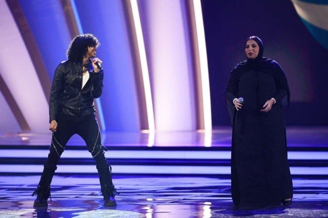  A cantora americana Trinidad Cardona (L) e a cantora do Qatar Aisha se apresentam durante o sorteio da Copa do Mundo de 2022 no Qatar, no Centro de Exposições e Convenções de Doha, em 1º de abril de 2022. (Foto de FRANCK FIFE / AFP)      
