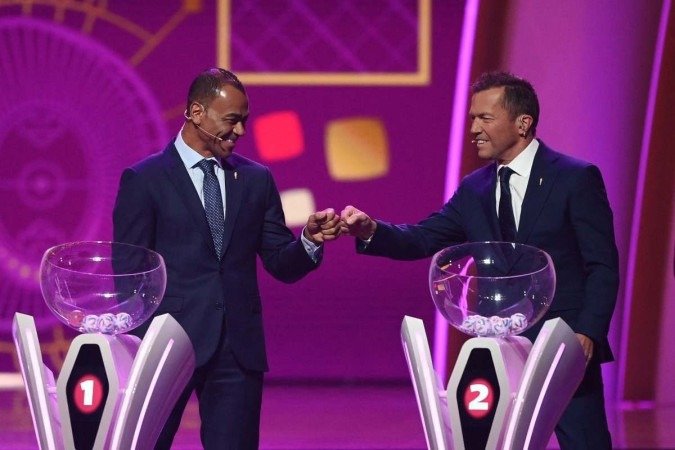  O ex-jogador brasileiro e vencedor da Copa do Mundo Cafu (L) cumprimenta o ex-jogador alemão Lothar Matthaus durante o sorteio da Copa do Mundo de 2022 no Qatar, no Centro de Exposições e Convenções de Doha, em 1º de abril de 2022. (Foto de FRANCK FIFE / AFP)      