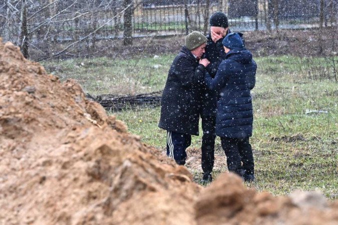 Moradores de Bucha, subúrbio de Kiev, aproximam-se de uma vala comum, onde foram encontrados 75 corpos de civis - (crédito: AFP) Moradores de Bucha, subúrbio de Kiev, aproximam-se de uma vala comum, onde foram encontrados 75 corpos de civis - (crédito: AFP)