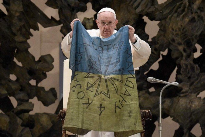 Papa Francisco segura bandeira ucraniana retirada da cidade de Bucha 
      