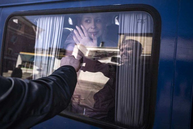 Uma mulher se despede do marido, ao embarcar em um ônibus, também em Kramatorsk