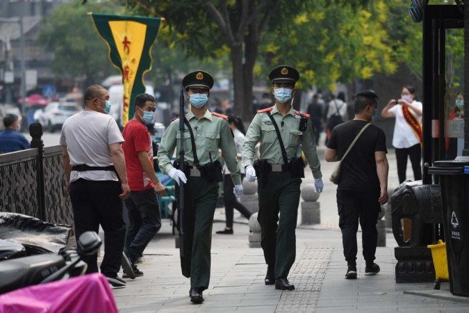 Foto ilustrativa de policiais nas ruas de Pequim -  (crédito: GREG BAKER/AFP)