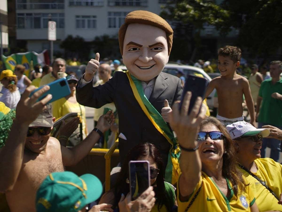  A supporter of Brazilian President Jair Bolsonaro impersonates him during a demonstration to show support for the president and his controversial ally, deputy Daniel Silveira, who Bolsonaro pardoned after the Supreme Court had sentenced him to prison time for his role leading a movement calling for the court to be overthrown, at Copacabana Beach in Rio de Janeiro, on May Day, on May 1, 2022. (Photo by Mauro PIMENTEL / AFP)       