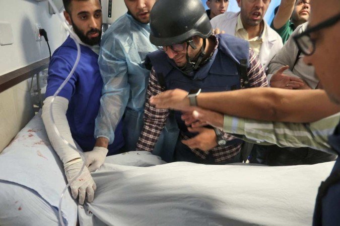 O cinegrafista Mujahed Al-Saadi (C) chora sobre o corpo da colega, em hospital de Jenin, na Cisjordânia