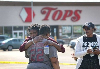 Moradores de Buffalo se abraçam diante do Tops Friendly Markets, no dia seguinte ao tiroteio em massa: cidade em choque após crime de ódio -  (crédito: Scott Olson/Getty Images/AFP)