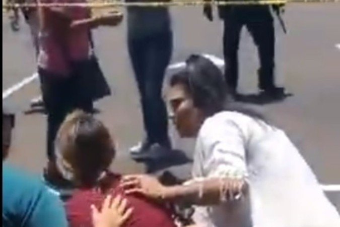 Sentada no meio-fio, mulher é consolada por duas pessoas: na tarde de terça-feira, pais viveram momentos de horror ante a falta de notícias, enquanto Salvador Ramos executava 19 crianças