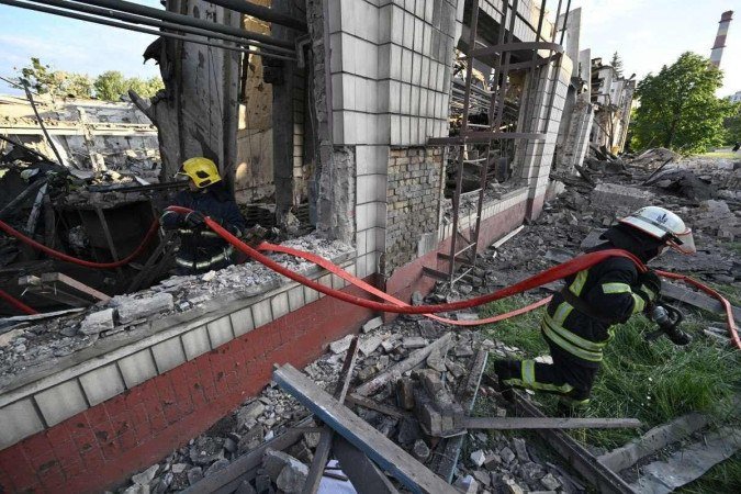 Bombeiros em depósito da fábrica de reparo de vagões, destruído na ofensiva deste domingo (5/6): pelo menos seis explosões -  (crédito:  AFP)