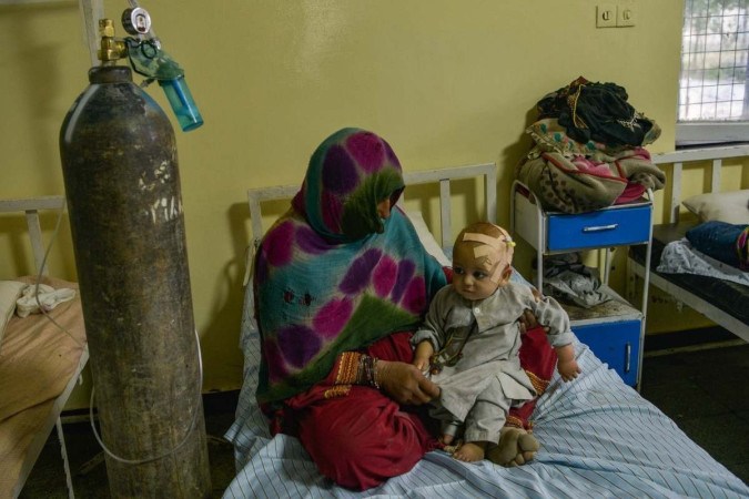 Criança ferida é amparada pela mãe em hospital da cidade de Sharan: socorro limitado