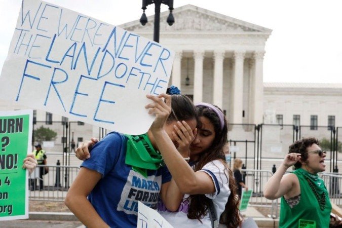 Mulheres choram na frente da Suprema Corte dos EUA, em Washington, após decisão sobre direito ao aborto - (crédito: Getty Images) Mulheres choram na frente da Suprema Corte dos EUA, em Washington, após decisão sobre direito ao aborto - (crédito: Getty Images)